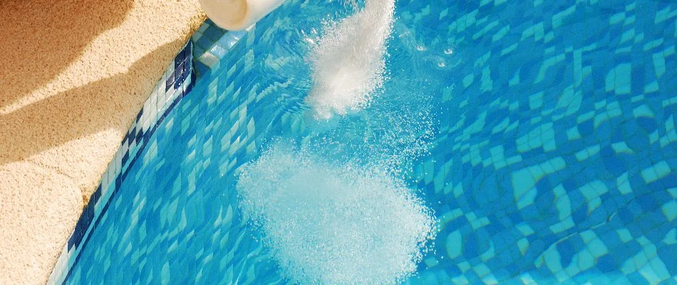 Adding chemicals to a pool in Bridgehampton, NY.