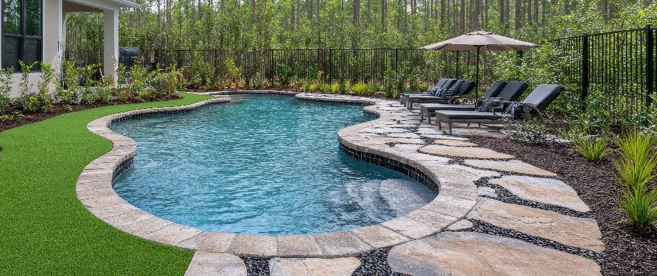 Freeform pool in Bridgehampton, NY, with lounge chairs.