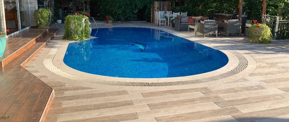 Inground pool in a backyard in Bridgehampton, NY, with furniture.