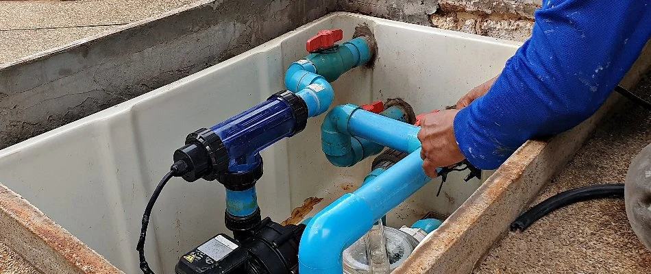 Man inspecting a pool pump system in Bridgehampton, NY.