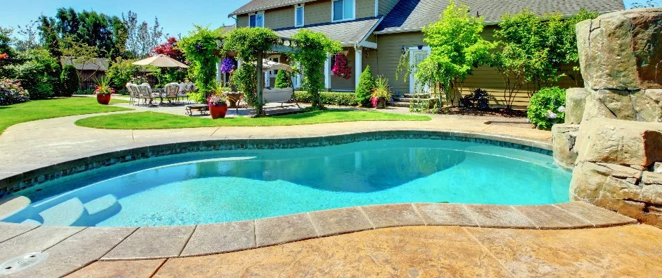Pool with decking in a backyard in Bridgehampton, NY.