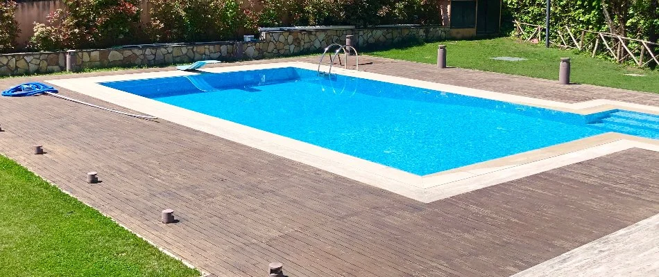 Wood decking around a pool in a yard in Bridgehampton, NY.