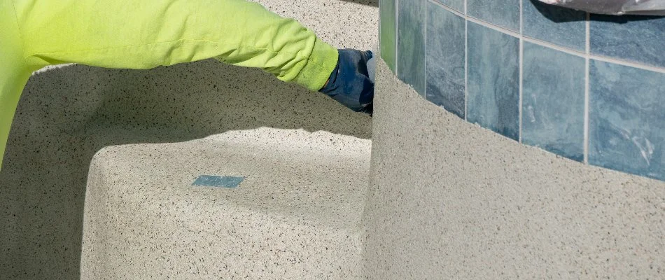 Worker applying a new pool finish in Bridgehampton, NY.