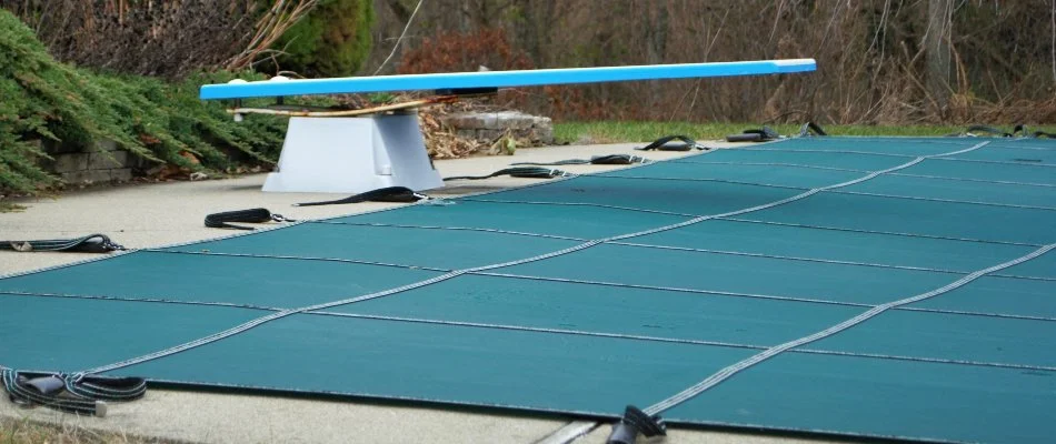 Diving board on a pool in Shinnecock Hills, NY, with cover.