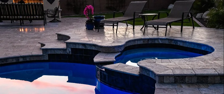 Lounge chairs by a pool in Hampton Bays, NY, with spa.