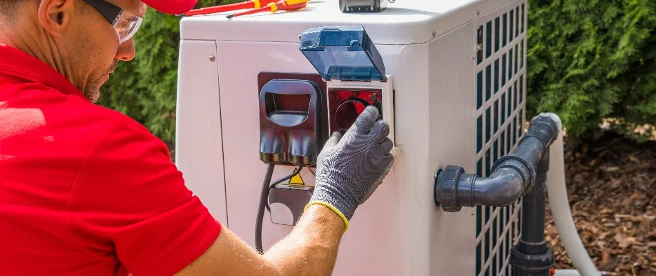 Person working on a pool heater on a property in Bridgehampton, NY.