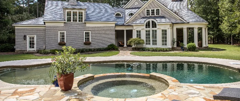 Pool, spa, and large house on a property in Bridgehampton, NY.