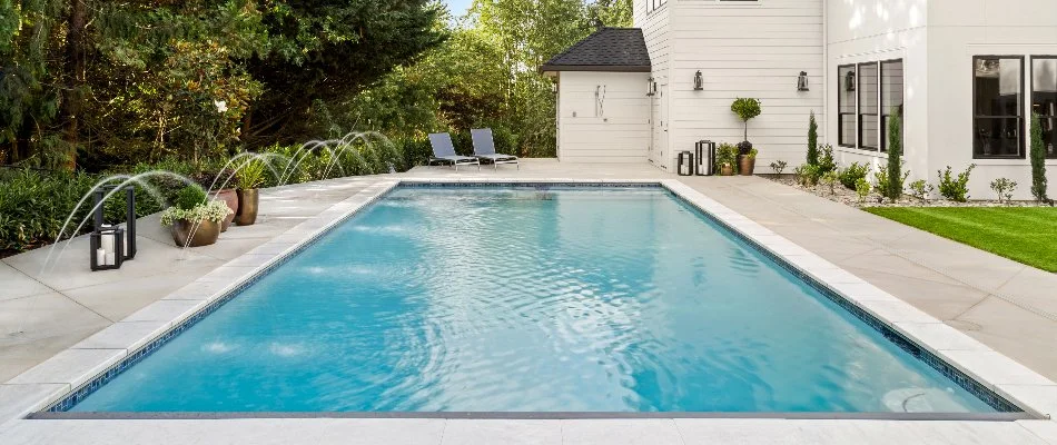 Pool with fountains on the side on a property in Bridgehampton, NY.