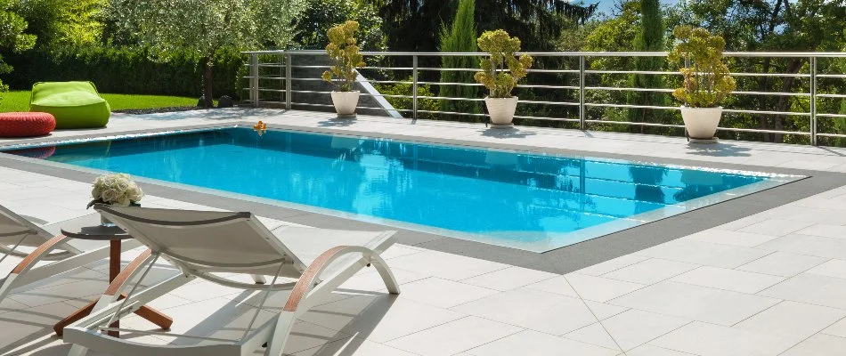 Swimming pool in Westhampton, NY, with lounge chairs and plants.